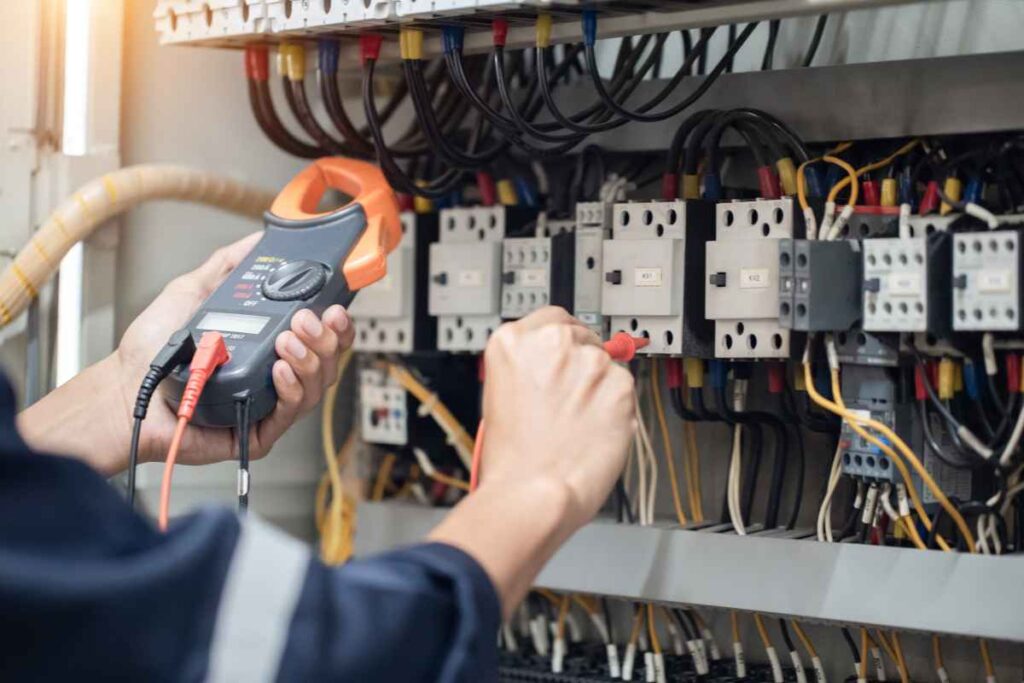 An electrician in Kansas City operates on a electrical board.