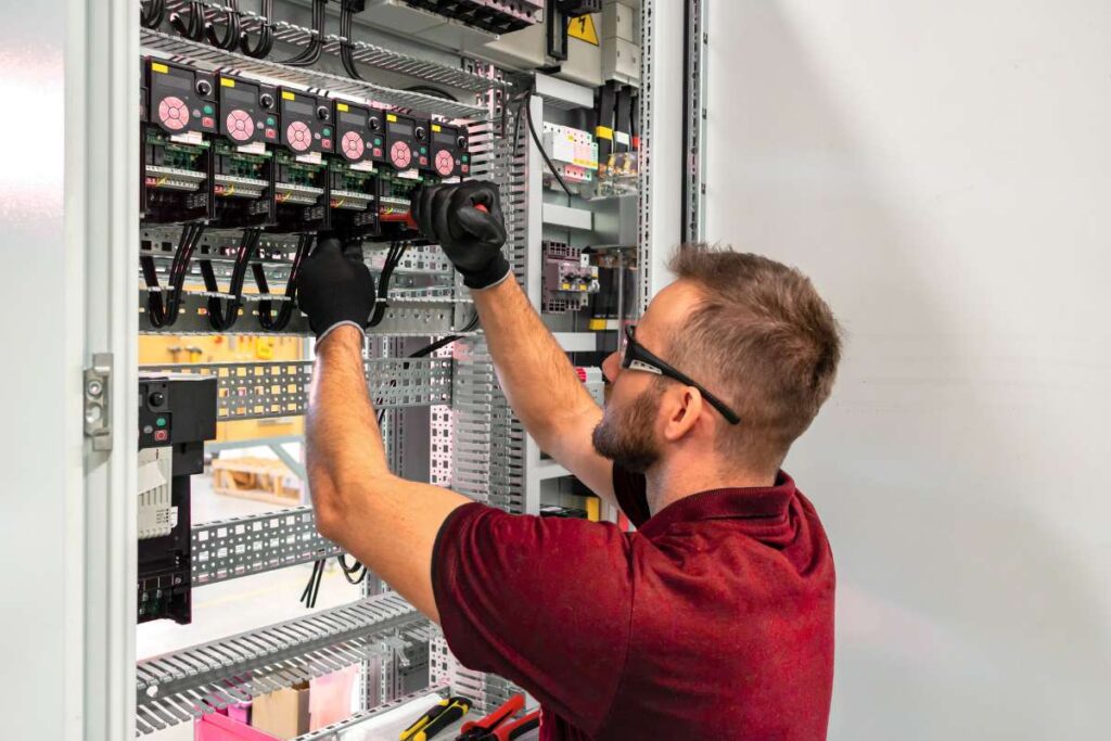 A commercial electrician in Olathe works on a panel.